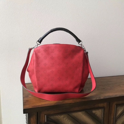 LV複刻版 M50031 紅色 Babylone 路易威登手袋採用了升級版的 Mahina 小牛皮， 精細的鏤花時尚而不失低調。 編織把手、對比色飾邊、時尚色彩等精美細節和全新線條令 Louis Vuitton Baby