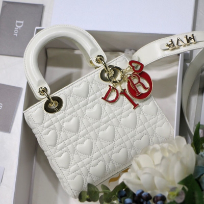 Dior迪奧 Lady Dioramour系列 M60104格 20cm 這款 手袋來自Amour 限定系列，集中體現了 對典雅和美麗的深刻洞見。結合精緻端莊的氣質與時髦現代的風範，是經久不衰的經典單品。採用奶白色羊皮革精心製作，以心形圖案