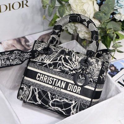 Dior迪奧 這款 Lady D-Lite 手袋將經典優雅的氣質與 Dior 品牌的時尚風貌融為一體。這款黑色單品通體飾以白色 Dior Around the World 圖案刺繡，點綴以對比鮮明的閃光和啞光刺繡線。正面飾以“CHRISTI