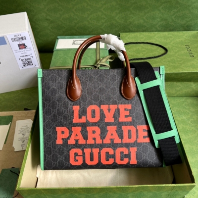 GUCCI古馳 Love Parade Gucci托特包，這款方形托特包飾有“Love Parade Gucci”印花，生動演繹了時裝秀的精髓，呼應了貫穿整個系列的俏皮趣味設計美學。黑pvc和綠色皮革滾邊為標誌性GG Supreme帆布增添