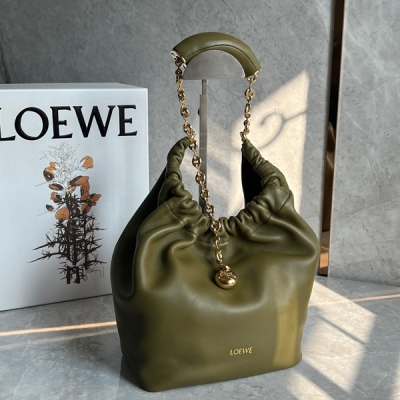 Loewe羅意威 現款Squeeze腋下包包上市啦 這款包以其褶設計感的Hobo造型展現出高級慵懶感和柔和的女性魅力，由Nappa帕羊皮製成，包身柔軟絲滑，光澤閃亮如綢緞，金色圓形小球的點綴，與觸感絲滑的皮革相得益彰 其特色在於甜甜圈形狀的