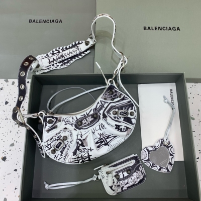 Balenciaga巴黎世家 Le Cagole半月牙腋下包斜挎包 塗鴉款 致敬經典機車包系列重磅新款王炸登場 在傳統的機車包上做了改良 可調節編織肩帶附加孔眼和外掛皮革卡包、心型掛鏡 沿用經典機車元素 細節非常講究 上身簡直癡迷 復古率性