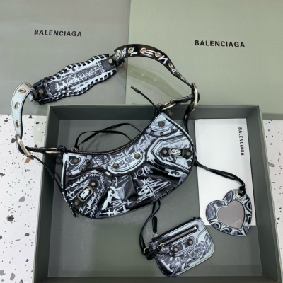 Balenciaga巴黎世家 Le Cagole半月牙腋下包斜挎包 塗鴉款 致敬經典機車包系列重磅新款王炸登場 在傳統的機車包上做了改良 可調節編織肩帶附加孔眼和外掛皮革卡包、心型掛鏡 沿用經典機車元素 細節非常講究 上身簡直癡迷 復古率性
