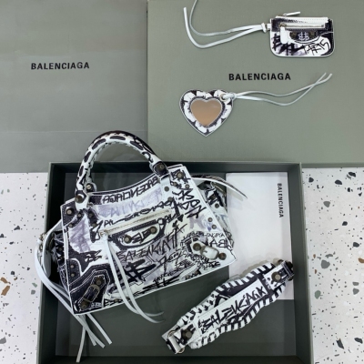 Balenciaga巴黎世家 最新款Neo cagole機車包 這次配備了愛心小鏡子，酷颯的外表下是一顆甜心 拎上就能提升整個氣場，輕而易舉的帥一地呀，甜心辣妹必入 尺寸：26x13x18cm 白色塗鴉銀扣
