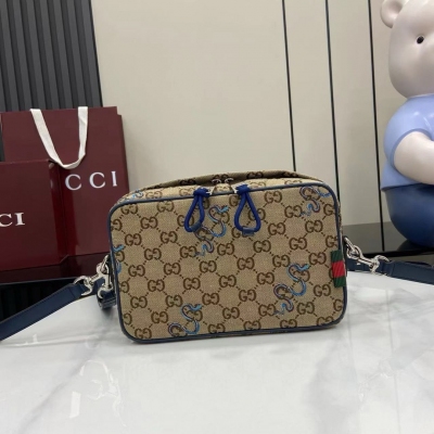 Gucci古馳 新品 G家浮雕標識，以高頻壓印技術打造 蛇型圖案以印花或刺繡細節匠心呈現，與品牌標識相映成趣，為2025早春系列的多款男士手袋增色添彩。這款米色和深棕色Original GG帆布背包因藍色撞色蛇型刺繡而倍添魅力。藍色牛皮革和