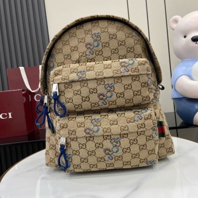 Gucci古馳 新品 蛇型圖案以印花或刺繡細節匠心呈現，與品牌標識相映成趣，為2025早春系列的多款男士手袋增色添彩。這款米色和深棕色Original GG帆布背包因藍色撞色蛇型刺繡而倍添魅力。背包廓形巧妙綴飾織帶提環細節。米色和深棕色Or