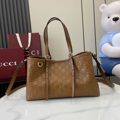 Gucci古馳 新品 2025秋冬系列, GG Emblem系列煥新詮釋品牌的雋永優雅風範和精湛工藝。這款水桶包採用同色調棉質襯裡，設有一個內部隔層，實用性出眾。棕色印花壓紋GG牛皮革 淺金色調襯裡 棕色棉質襯裡 鉤扣開合頂部手柄（高度：1