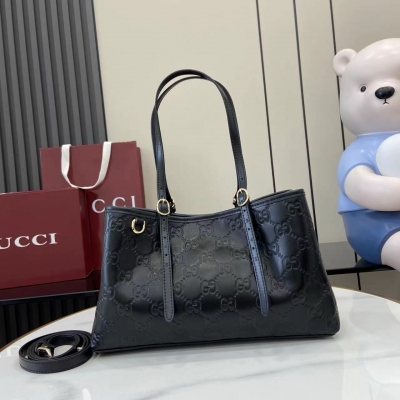 Gucci古馳 新品 全新GG Emblem系列煥新詮釋品牌的雋永優雅風範和精湛工藝。這款托特包配有一根飾有示數孔眼的可調節頂部提手，靈感源自馬術世界。黑色壓花皮革 黑色超細纖維襯裡 圖中所示手袋單獨出售，不隨手袋掛飾一起提供。另配有用於系