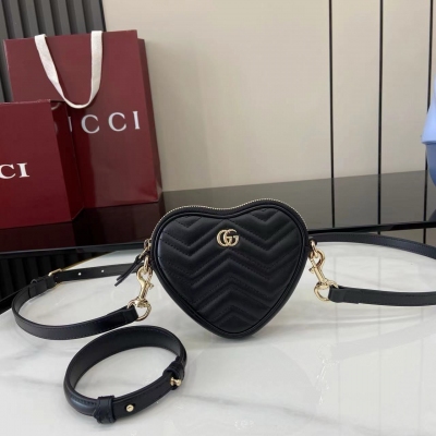 Gucci古馳 新品 這款GG Marmont系列迷你手袋採用俏皮可愛的心形廓形，以柔軟的黑色V型Matelassé牛皮革匠心打造。包身造型簡潔小巧，配以淺金色調標誌性雙G配件。黑色絎縫V型牛皮革 淺金色調配件 棕色塔夫綢襯裡 雙G 內部：