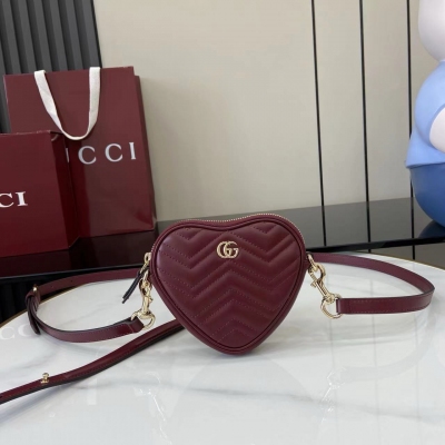 Gucci古馳 新品 這款GG Marmont系列迷你手袋採用俏皮可愛的心形廓形，以柔軟的黑色V型Matelassé牛皮革匠心打造。包身造型簡潔小巧，配以淺金色調標誌性雙G配件。黑色絎縫V型牛皮革 淺金色調配件 棕色塔夫綢襯裡 雙G 內部：