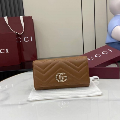 Gucci古馳 新品 GG Marmont系列長款皮片夾採用絎縫牛皮革打造，配以V形紋設計，背面裝飾 GG 標誌。新棕色V形紋絎縫牛皮革 復古金色金屬配件 雙 G 內部：十二個卡片隔層、兩個鈔票隔層、兩個獨立的內部隔層和一個拉鍊零錢袋 外部