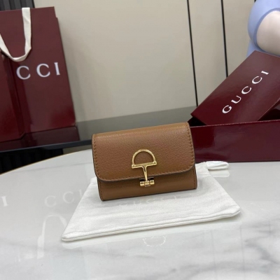 Gucci古馳 新品 Gucci延續品牌深厚傳承，深化與馬術本源的聯結。半馬銜扣圖案化身為開合細節，為多款小皮件增色添彩。這款卡片夾以古馳棕色粒面牛皮革匠心打造，經典元素點綴其上。古馳棕色粒面牛皮革 淺金色調配件 半馬銜扣 內部：一個拉鍊袋